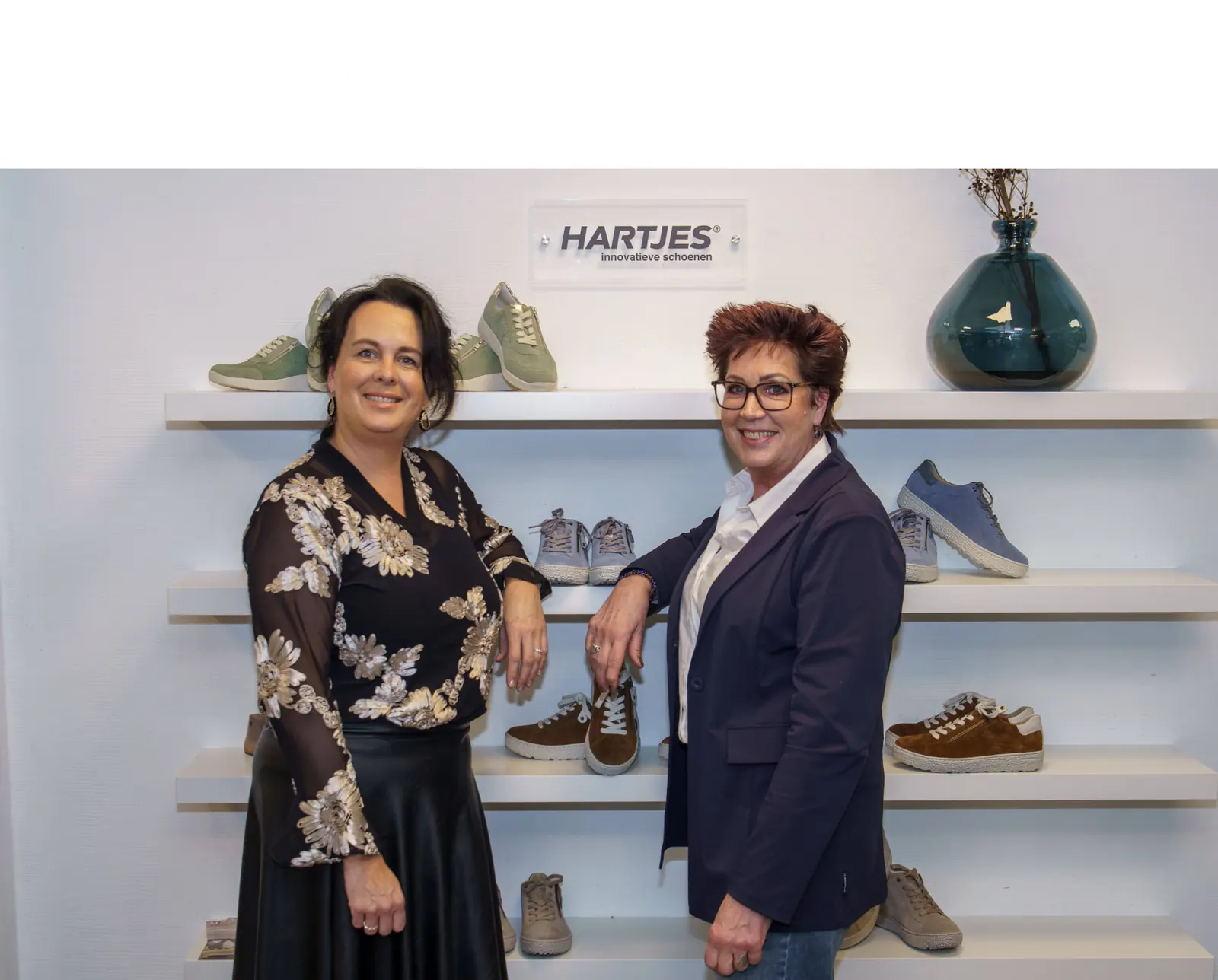 Twee medewerkers van Boudesteyn Schoenen tussen de schoenencollectie